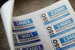 A sheet of paper with iso registered stickers on it