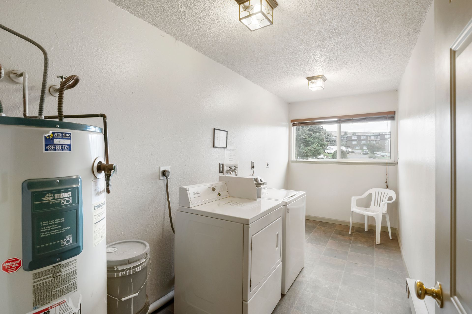 A laundry room with a washer and dryer and a water heater.