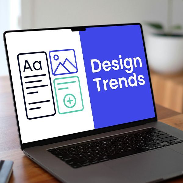 A laptop with the words design trends on the screen