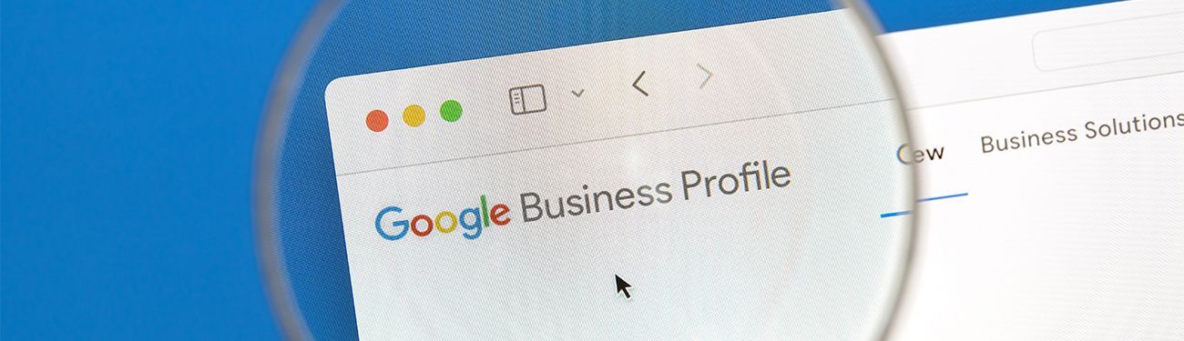 A magnifying glass highlights the Google Business Profile logo 