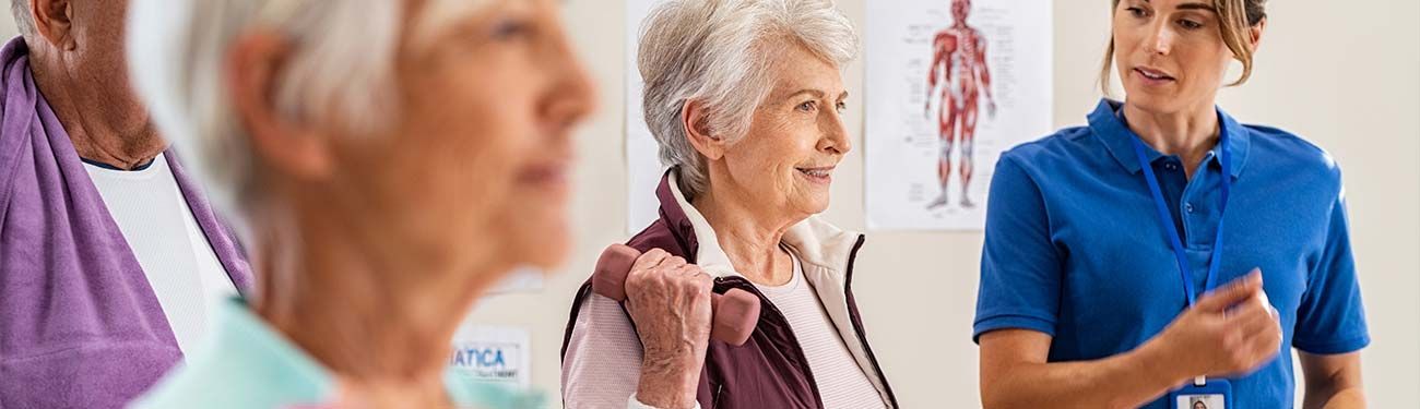 A group of elderly people are sitting in a room with a nurse.