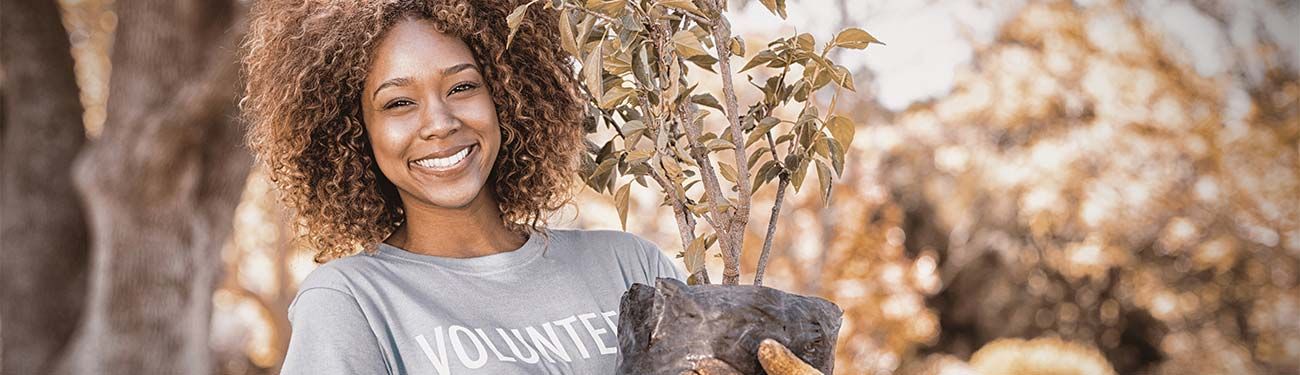 A woman is holding a cat in her arms and smiling.