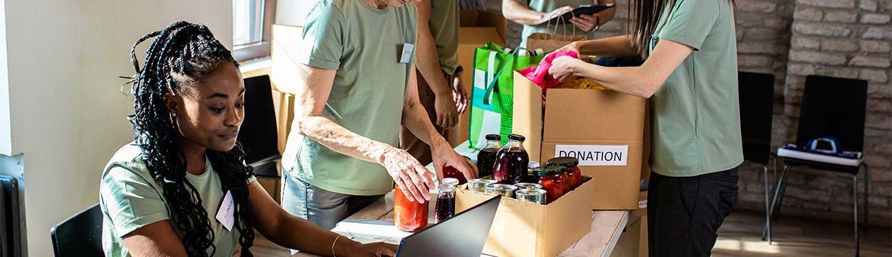 A group of people are standing around a table.