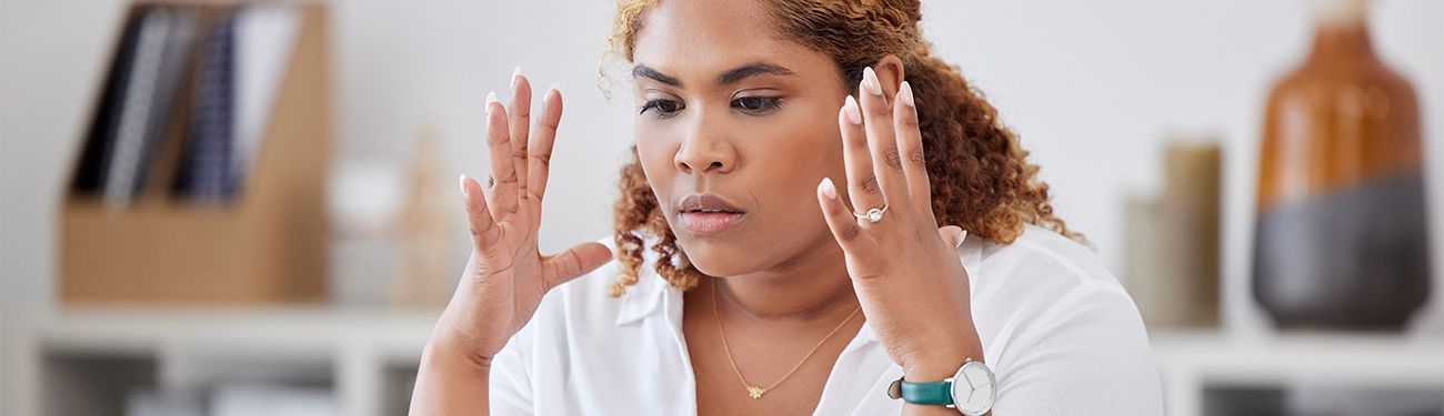 Woman holding her head in her hands, stressed.