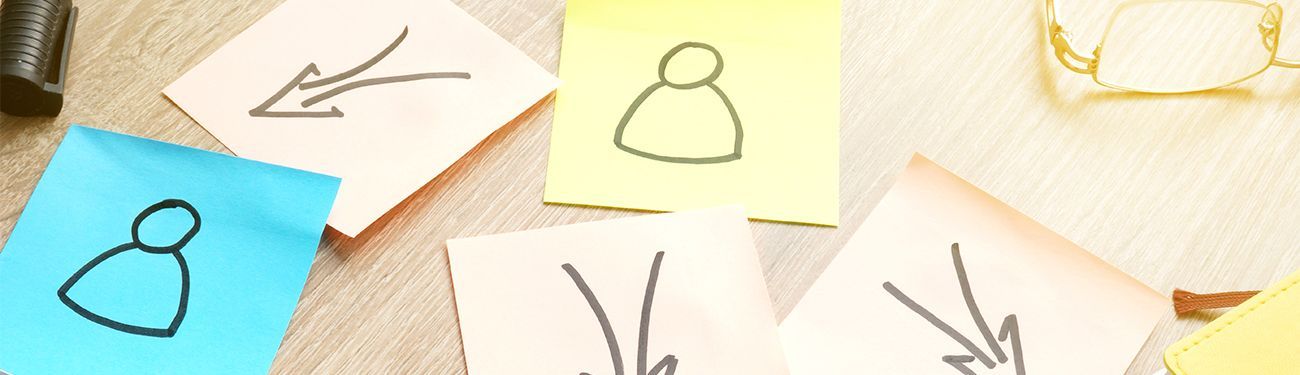 A bunch of sticky notes with arrows on them on a table.