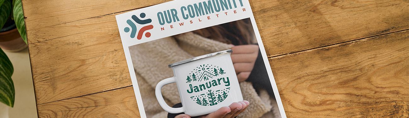 A person is holding a mug on a wooden table.