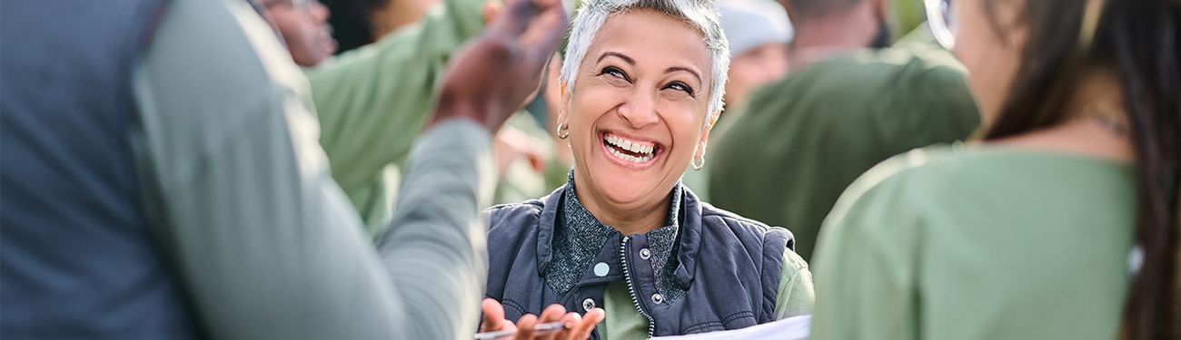 A woman is smiling in a crowd of people.