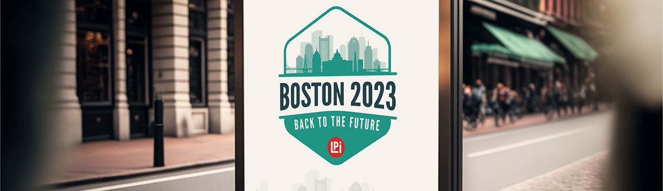 A billboard is sitting on the side of a street in front of a building.