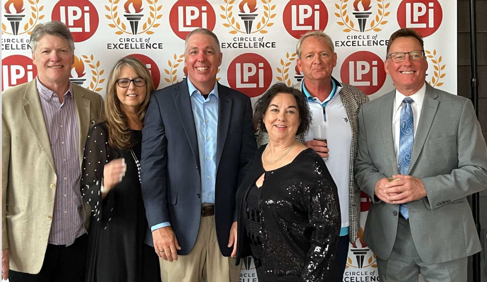 A group of people in suits and ties are posing for a picture.