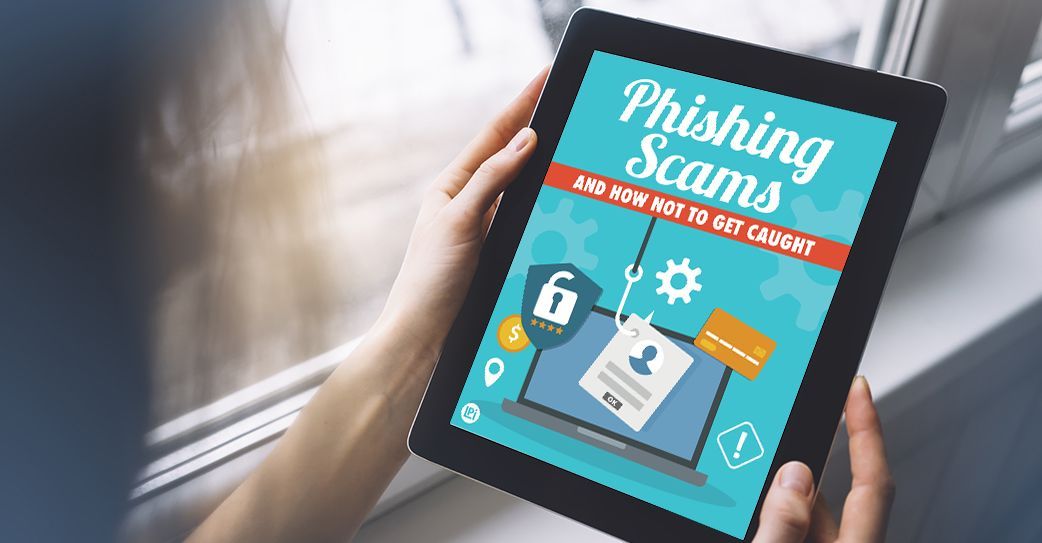 A person is holding a tablet with a phishing scams book on it.