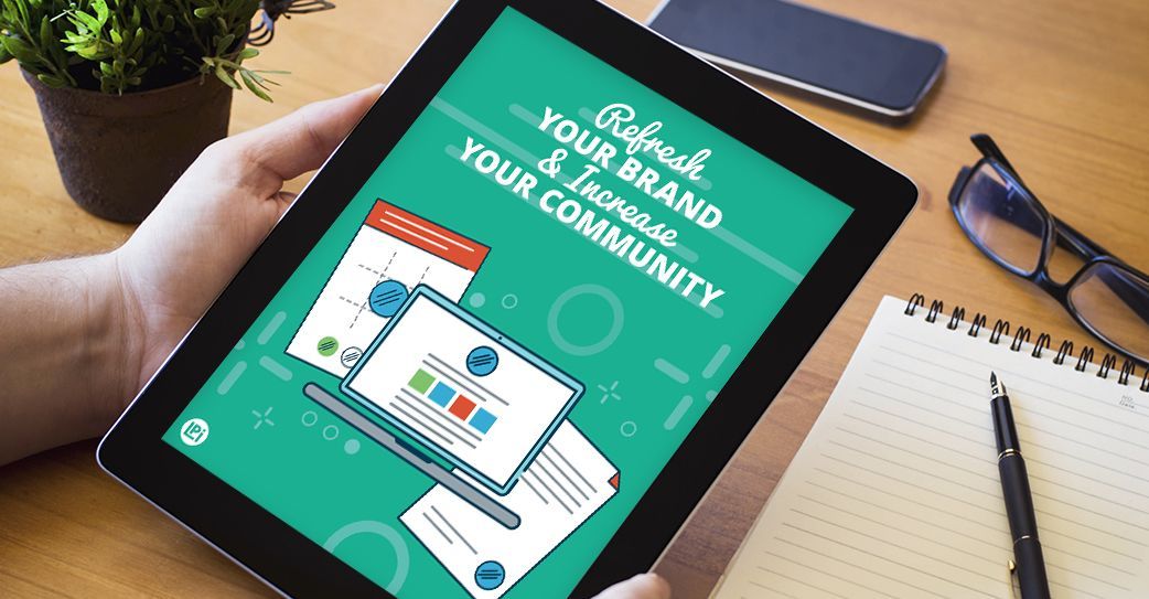 A person is holding a tablet that says refresh your brand and increase your community.