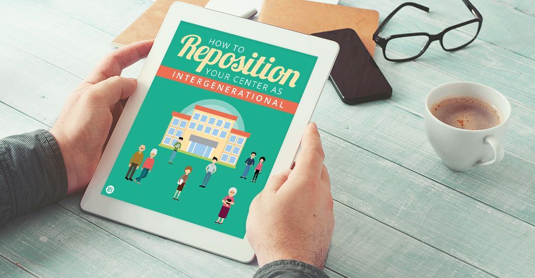 A person is holding a tablet with a picture of a school on it.