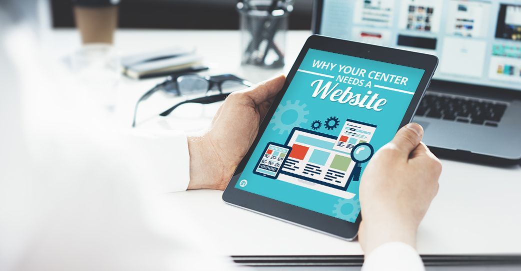 A person is holding a tablet with a website on the screen.