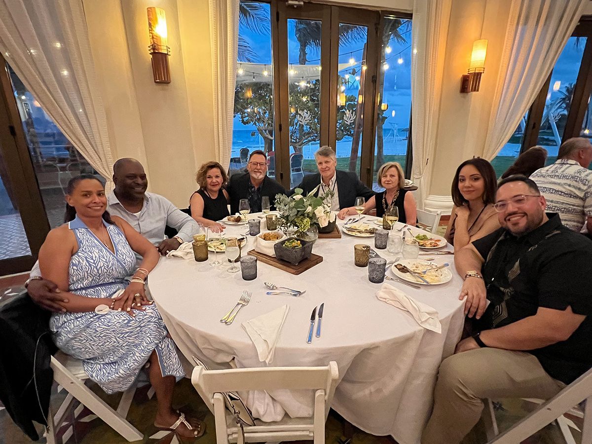 A group of people are sitting at a table with plates of food.