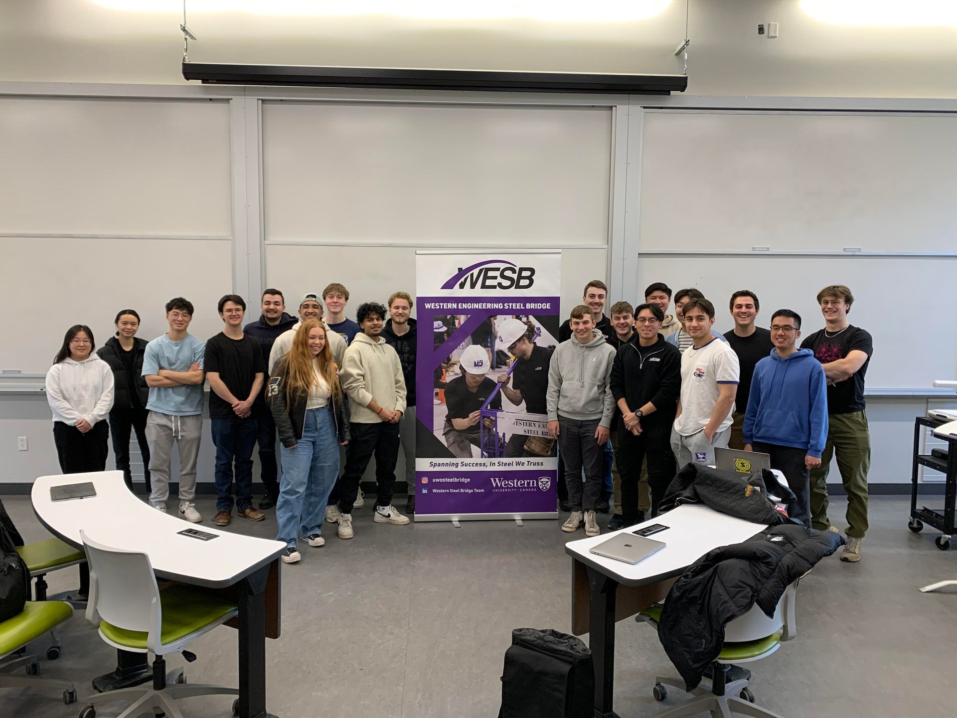 a group of people are posing for a picture in a classroom .