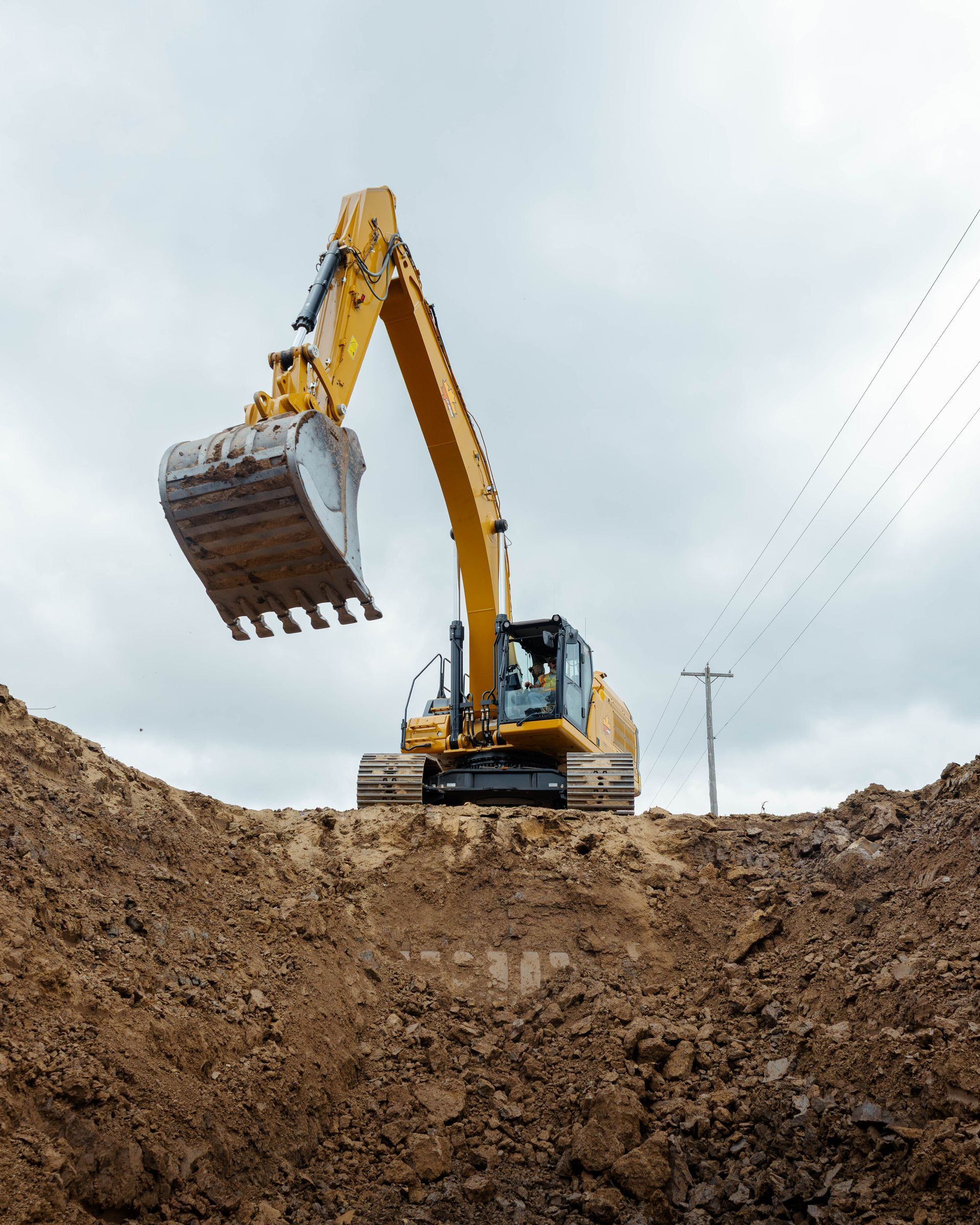 a yellow excavator is digging in a pile of dirt for excavating jobs