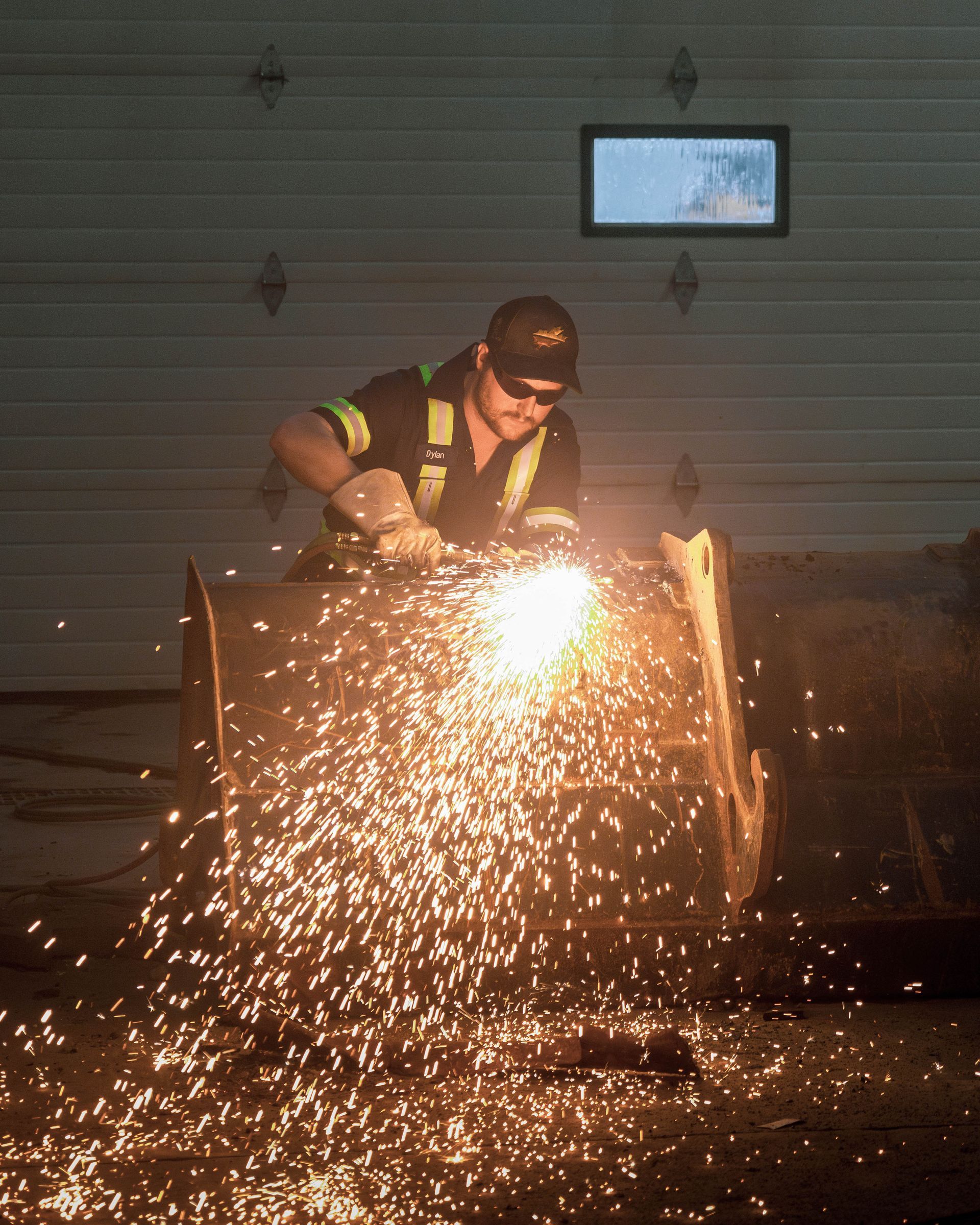 a group of construction workers are standing in front of a pile of pipes .