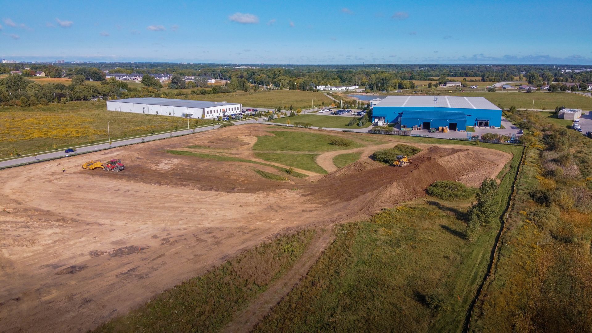 An aerial view of a large building under construction in the middle of a snowy field.