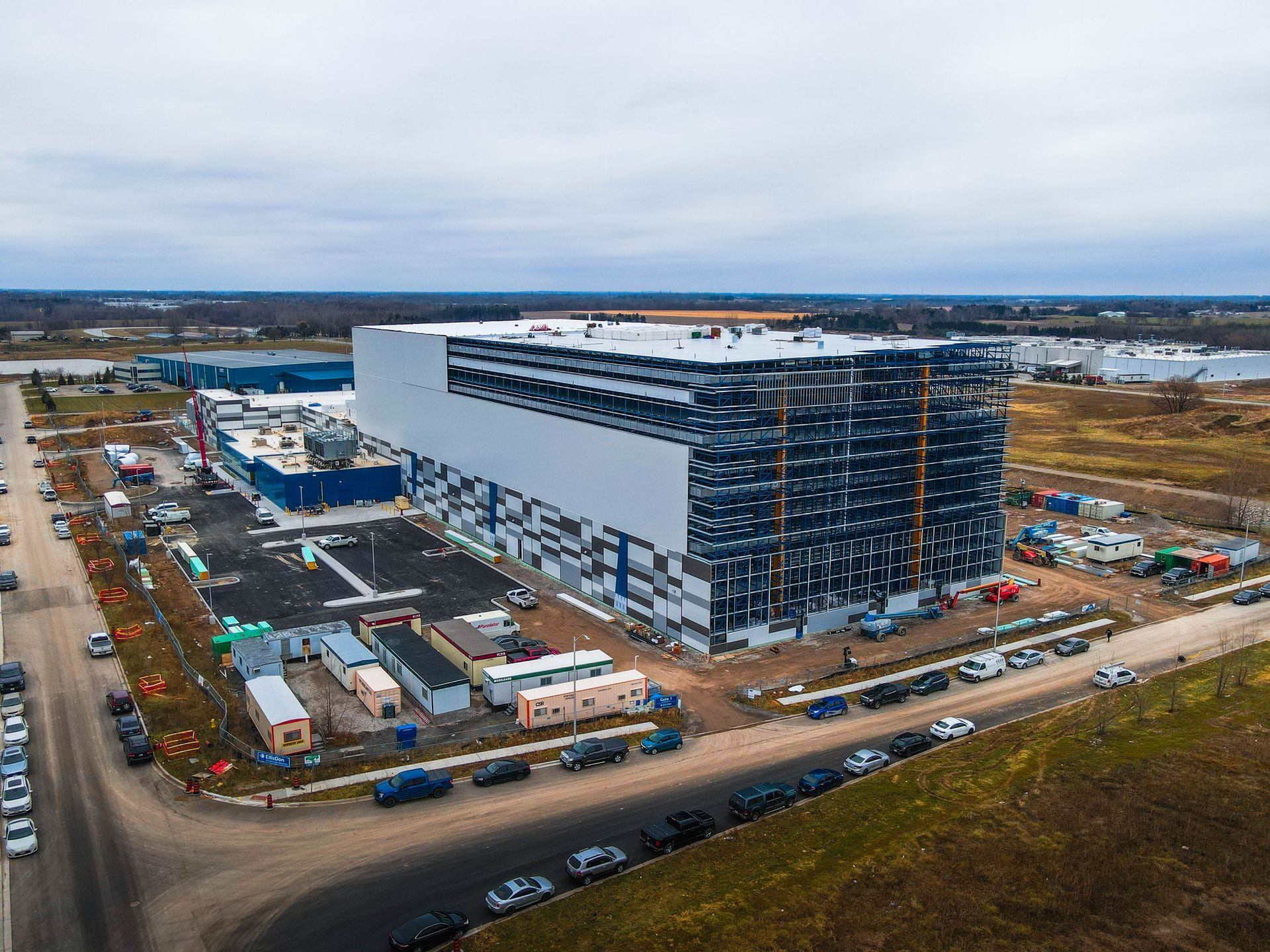 an aerial view of a large building with a lot of cars parked in front of it .