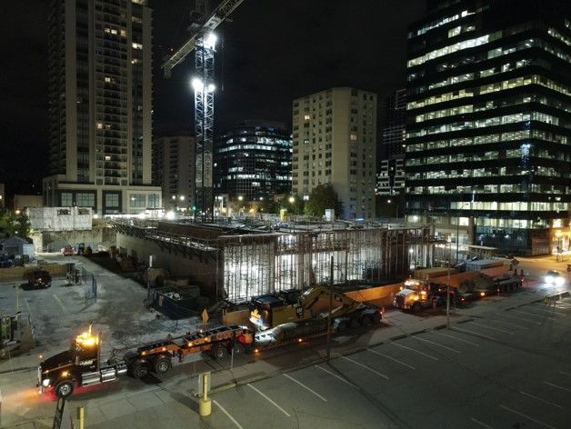 a construction site at night with a lot of trucks and cranes