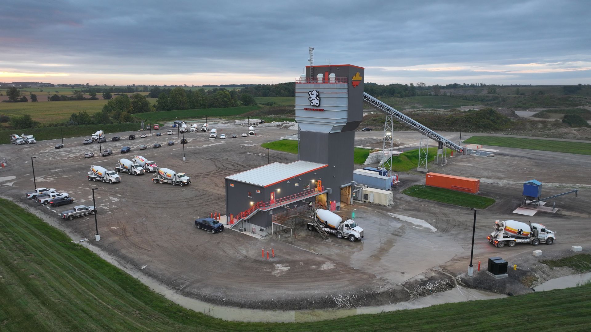 An aerial view of a concrete plant with trucks parked in front of it.