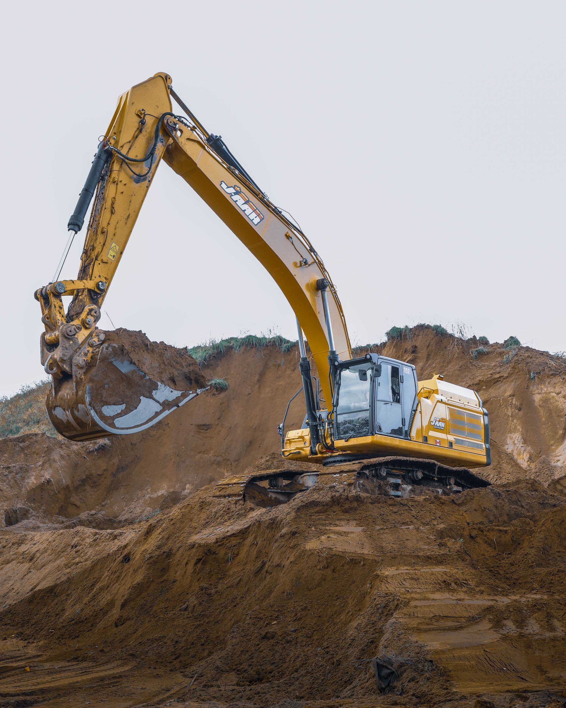 a yellow excavator is digging in a pile of dirt for excavating jobs