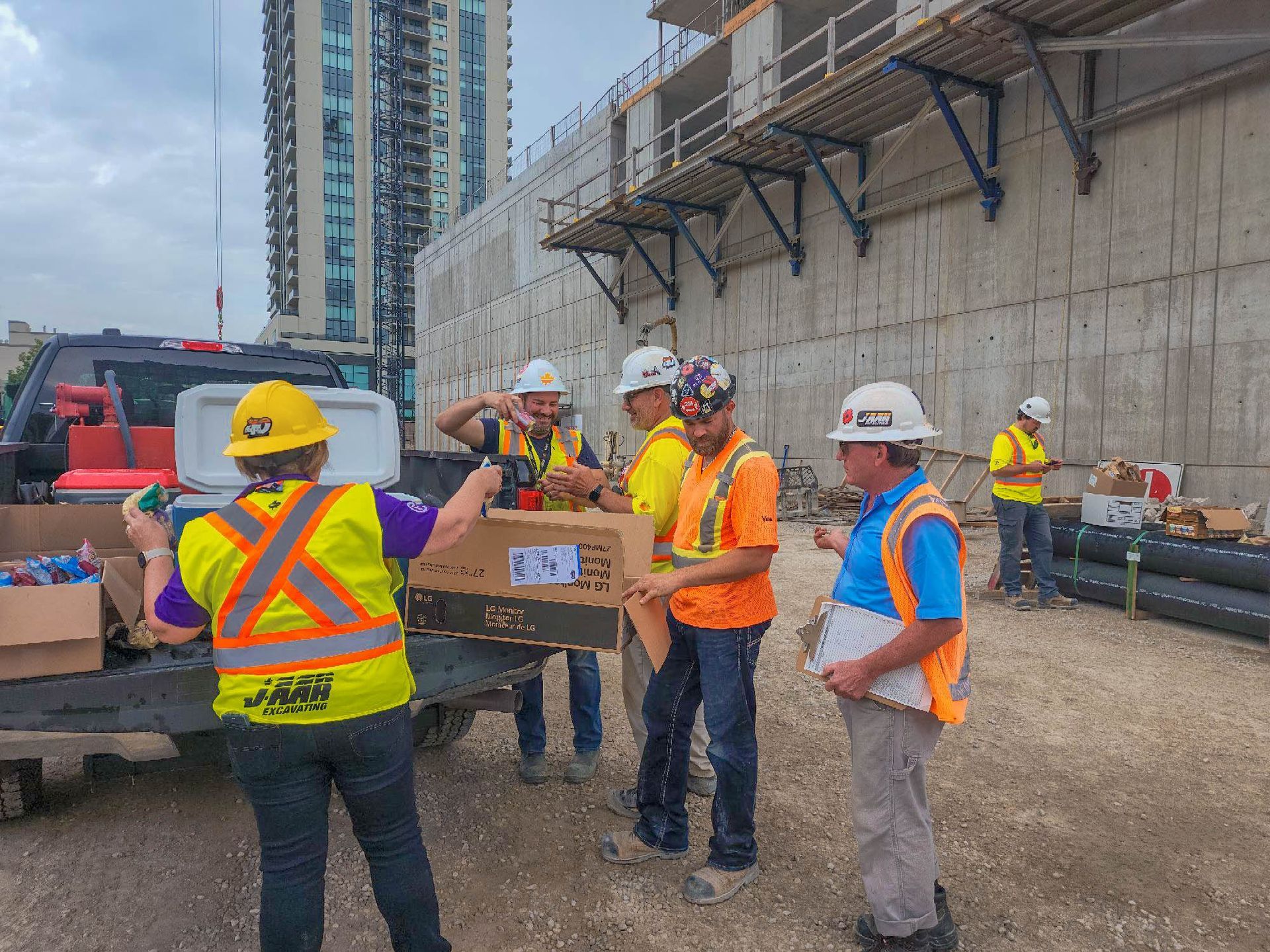 a group of construction workers are standing around a truck on a construction site .