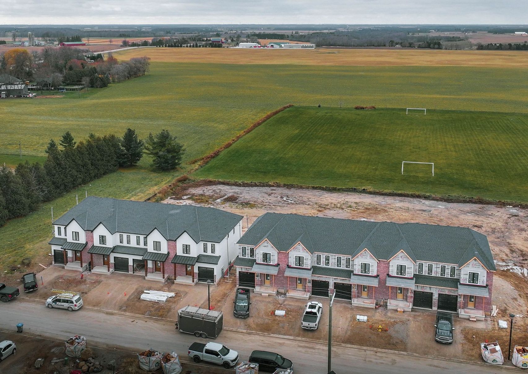 an aerial view of a row of houses with a field in the background .