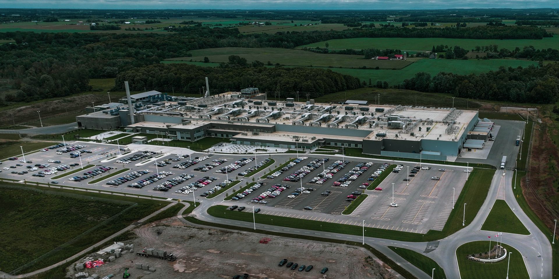 An aerial view of a large building with a lot of cars parked in front of it
