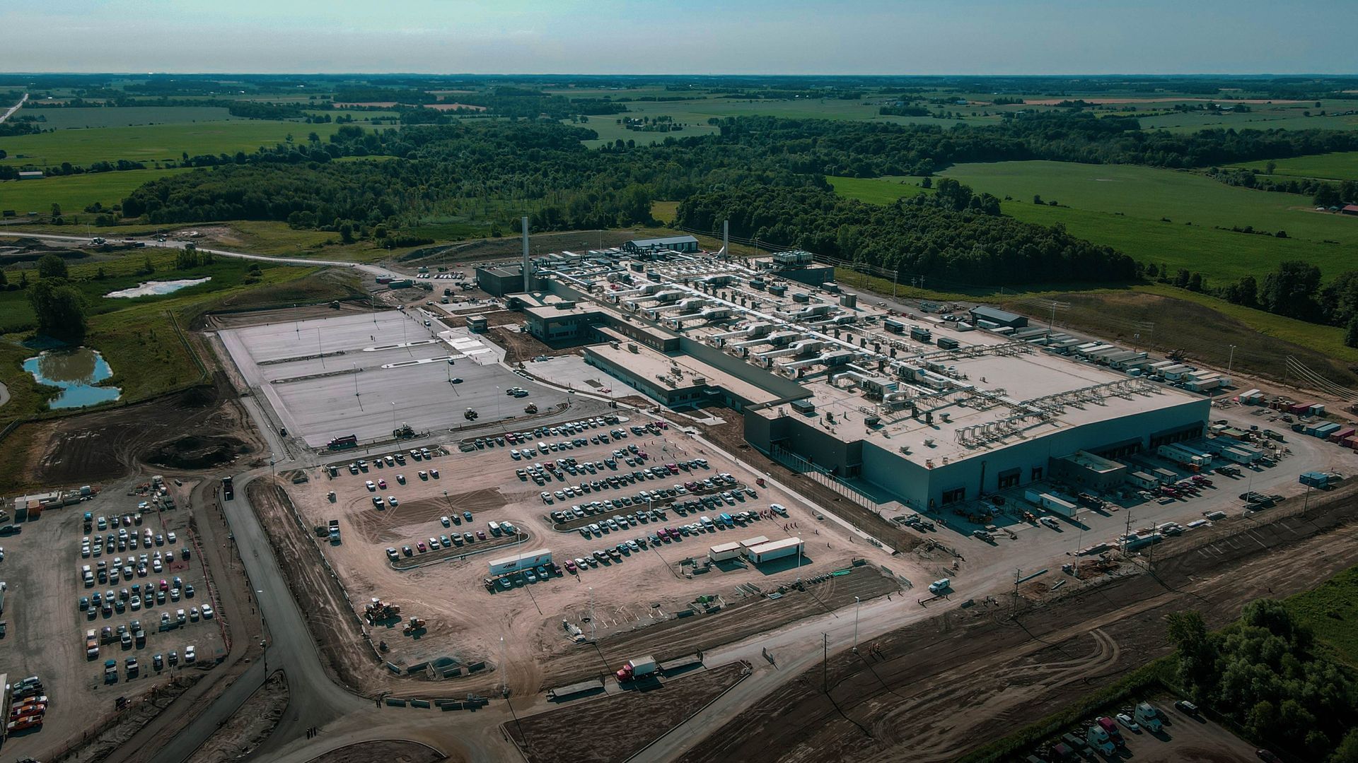 an aerial view of a large building with a lot of cars parked in front of it .