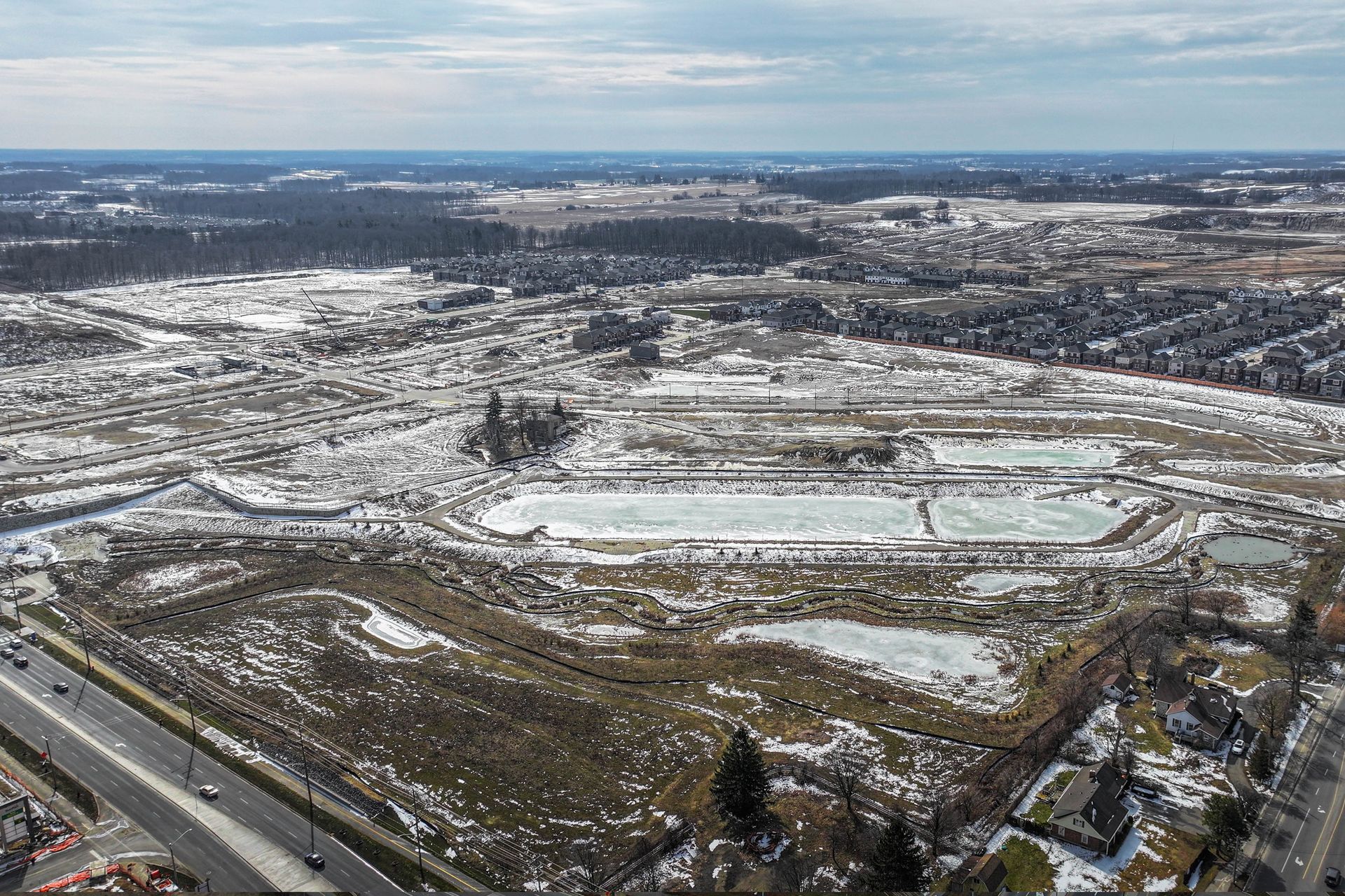 An aerial view of a snow covered field in the middle of a city.