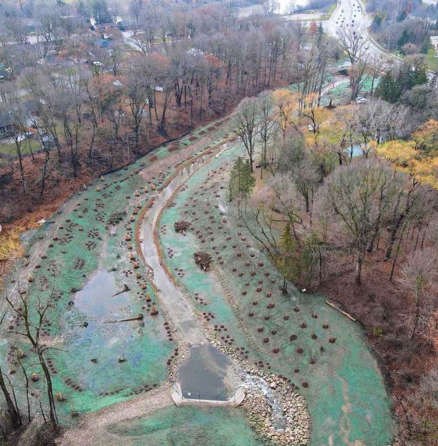 an aerial view of a park with trees and a pond .