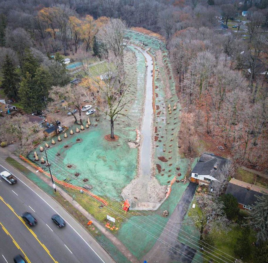 an aerial view of a road going through a forest