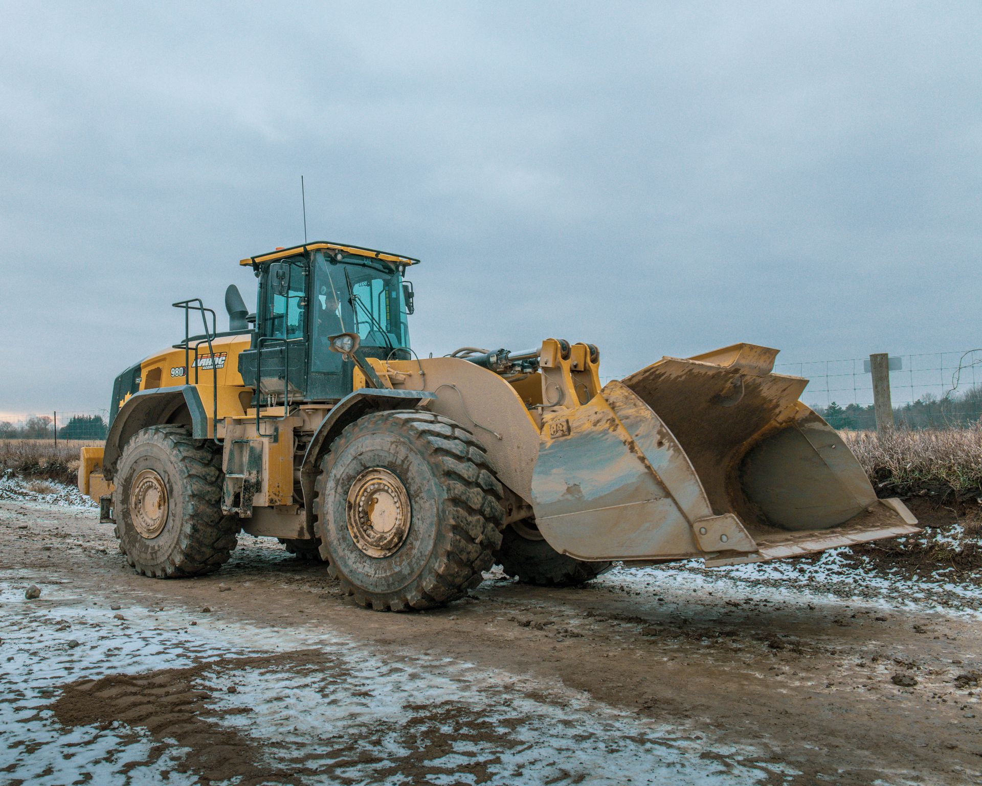 a yellow bulldozer is parked on a dirt road .