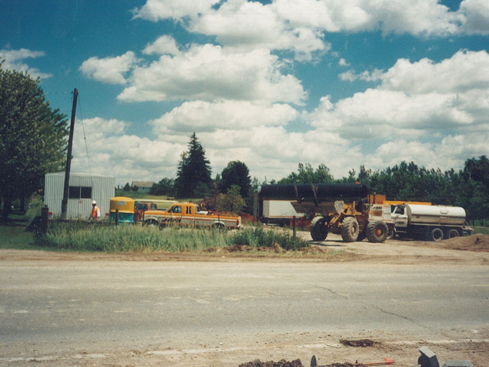 Vintage photo of a lot of trucks are parked on the side of the road
