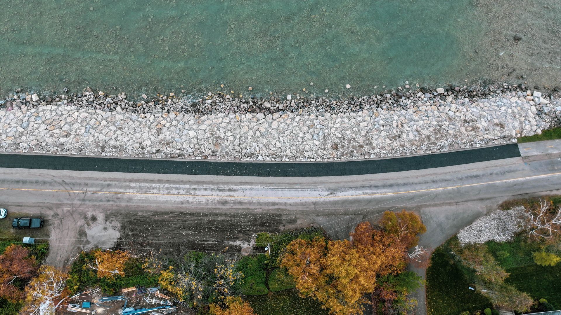 An aerial view of a road next to a body of water.