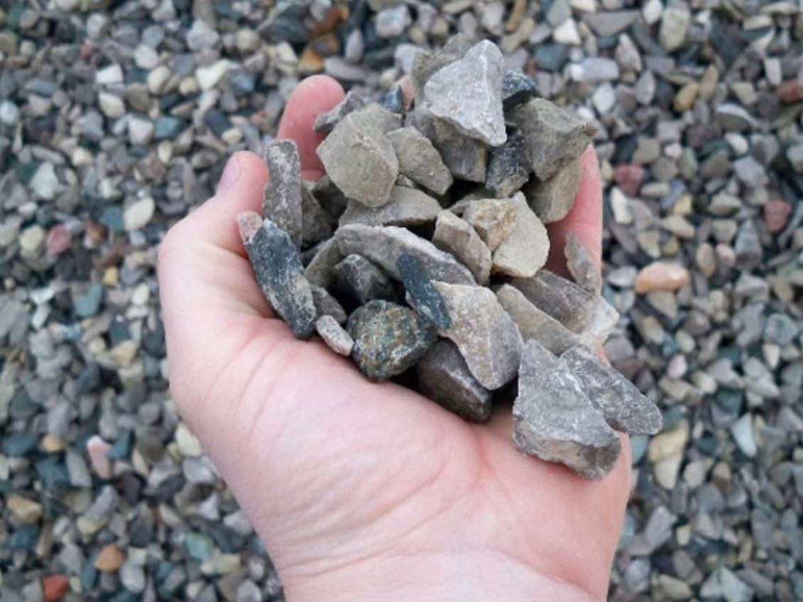 a person is holding a pile of rocks in their hand .
