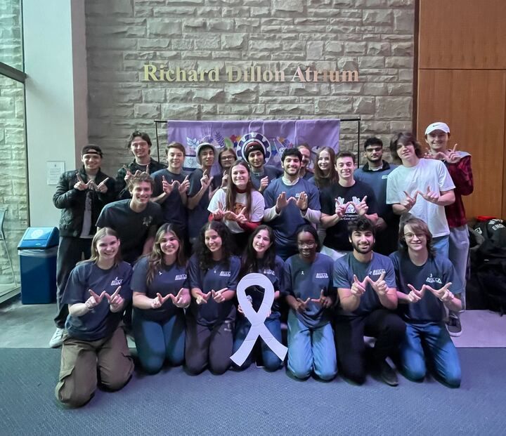 Western University students posing for a picture with a white ribbon
