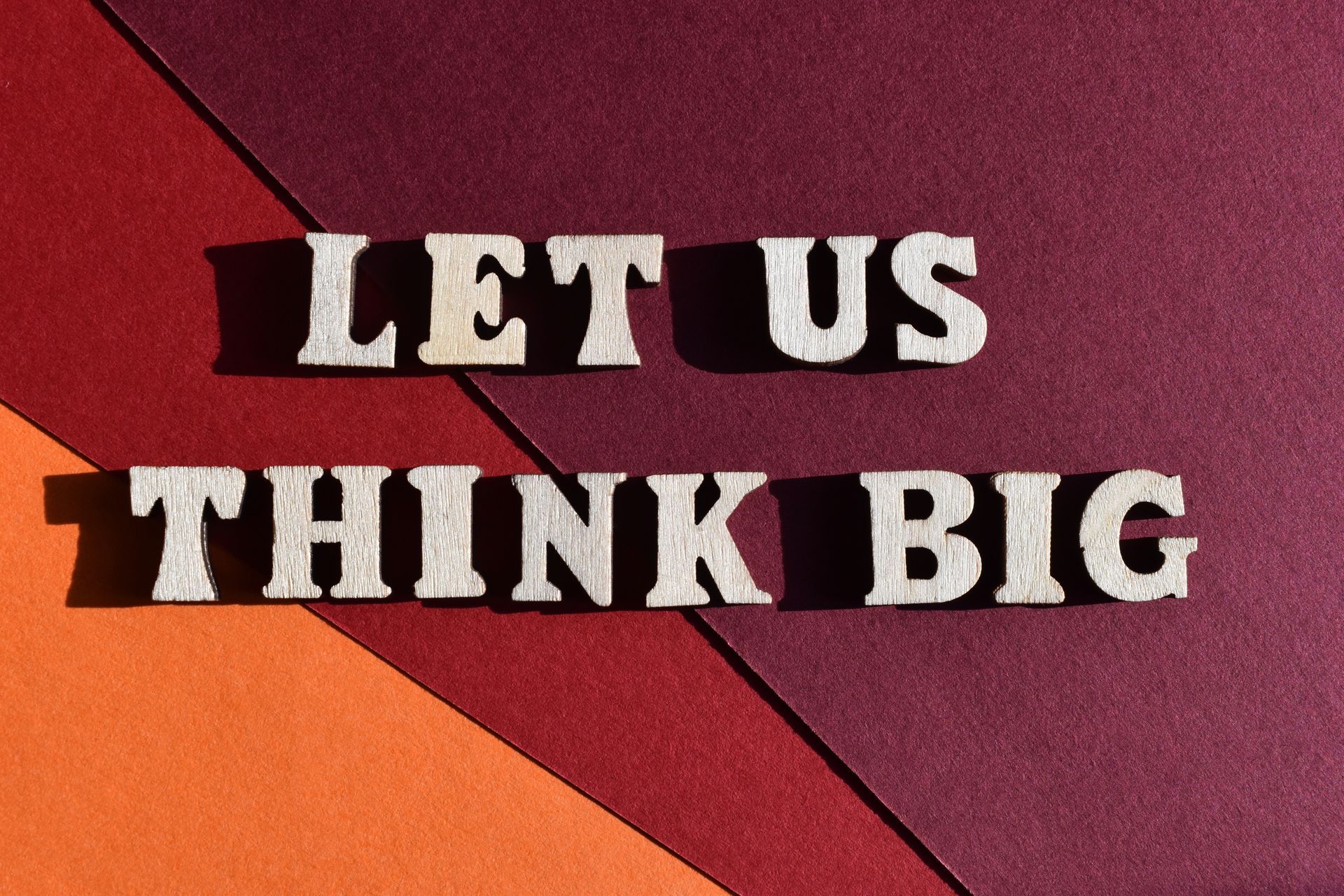 A sign that says let us think big on a colorful background