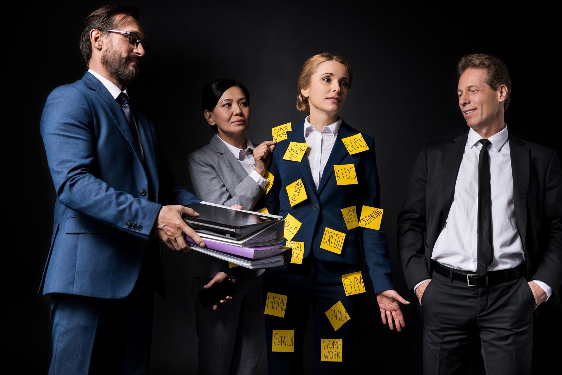 A group of business people are standing next to each other with sticky notes on their clothes.
