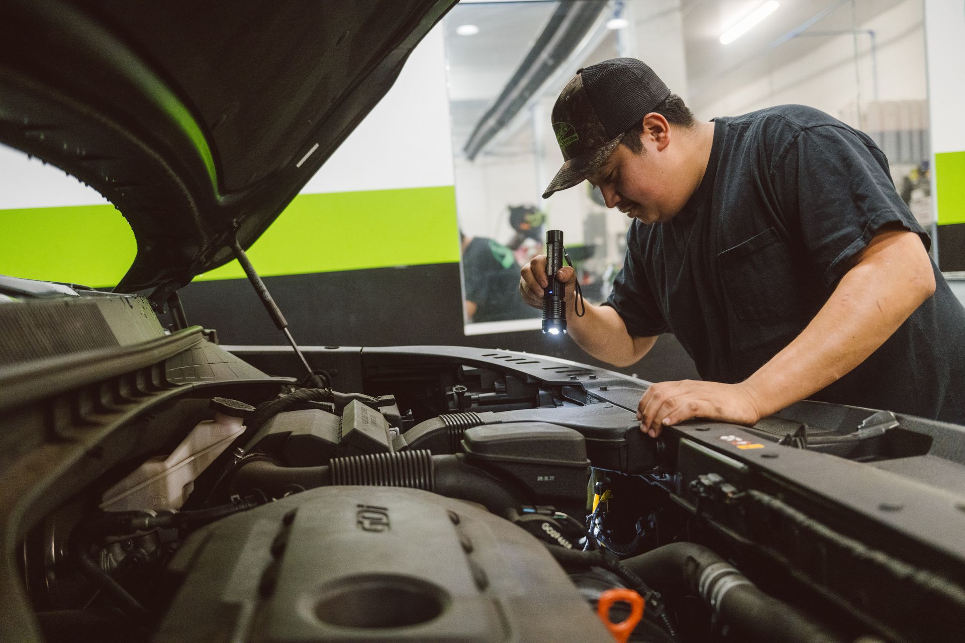 technician inspecting under the hood