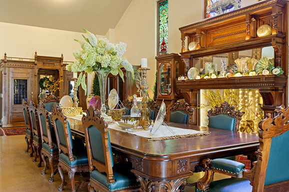 A dining room with a long wooden table and chairs.