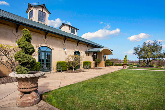 A large building with a lush green lawn in front of it.