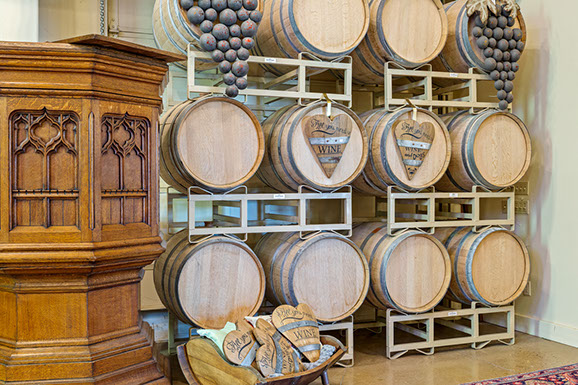 A bunch of wooden barrels are stacked on top of each other in a room.