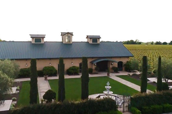 A large building with a blue roof and a fountain in front of it