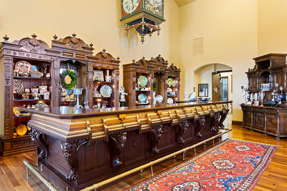 A large wooden bar in a room with a clock hanging from the ceiling.