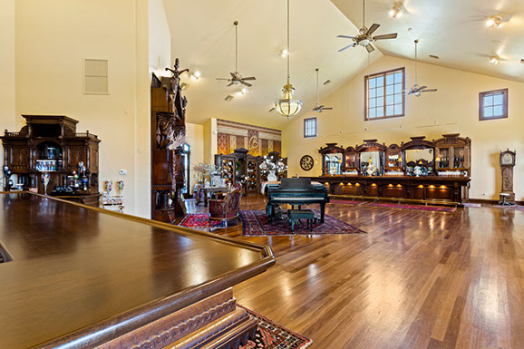 A large room with hardwood floors and a piano.