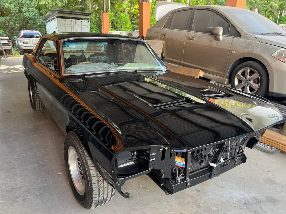A Black Car Is Sitting In A Parking Lot Next To A Silver Car — ABS Repairs in Manunda, QLD