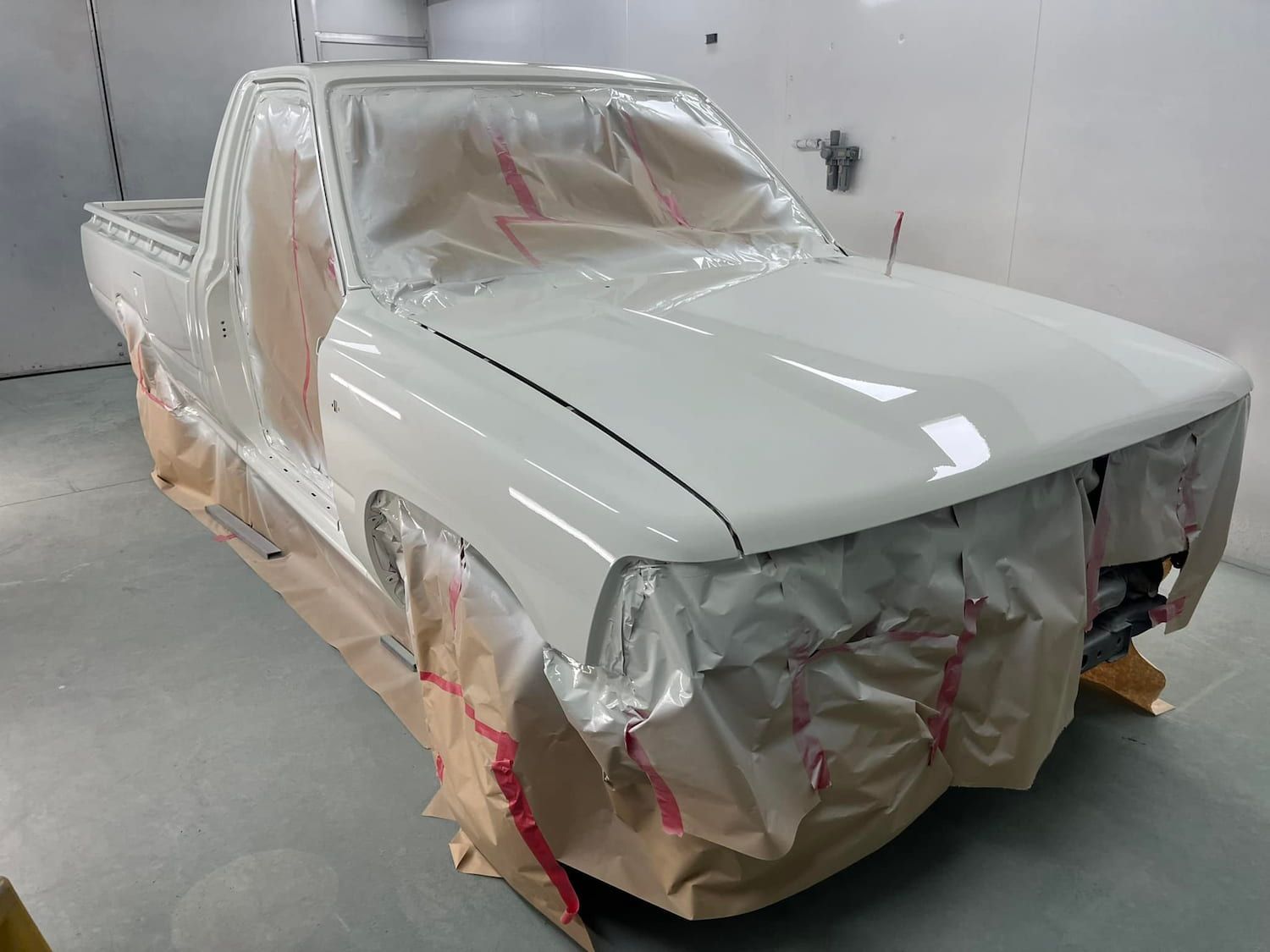 A White Truck Is Being Painted In A Paint Booth — ABS Repairs in Manunda, QLD