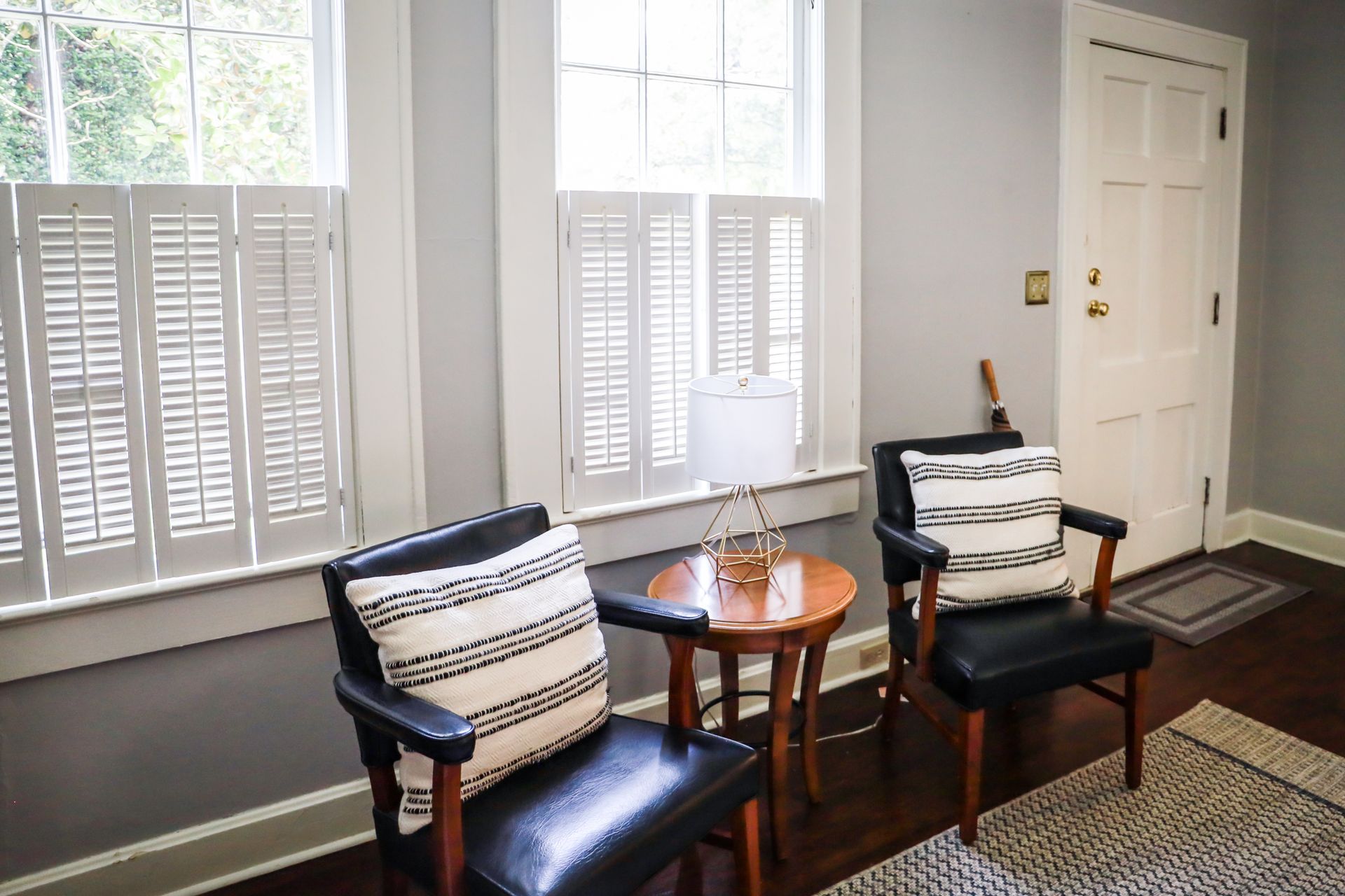 Interior shutters on two windows inside the entryway of a home